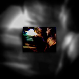 A picture of a person in a dark room looking towards a blinding light.