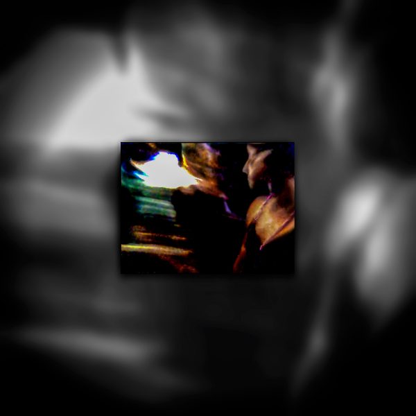 A picture of a person in a dark room looking towards a blinding light.