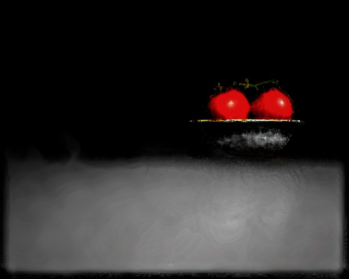 An artistic photograph of two tomatoes in a bowl.