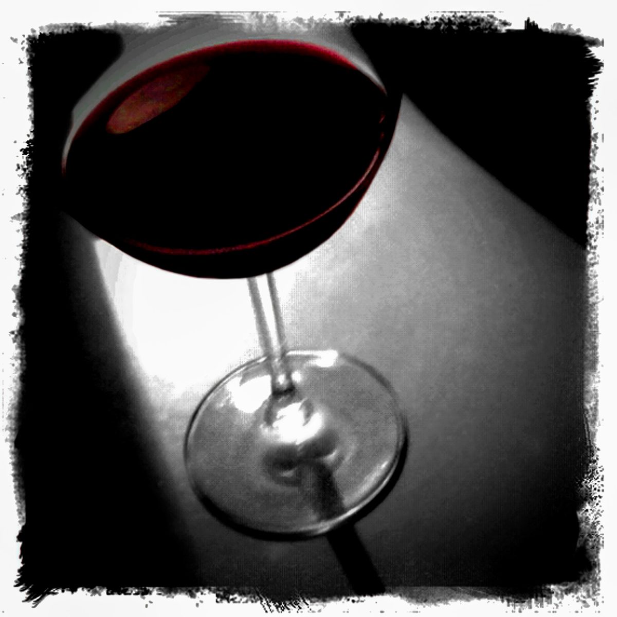 A glass of red wine on a table.