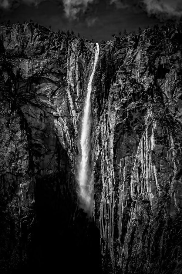 Majestic black and white waterfall in rugged canyon, part of The Doug Heslep Fine Art Collection.
