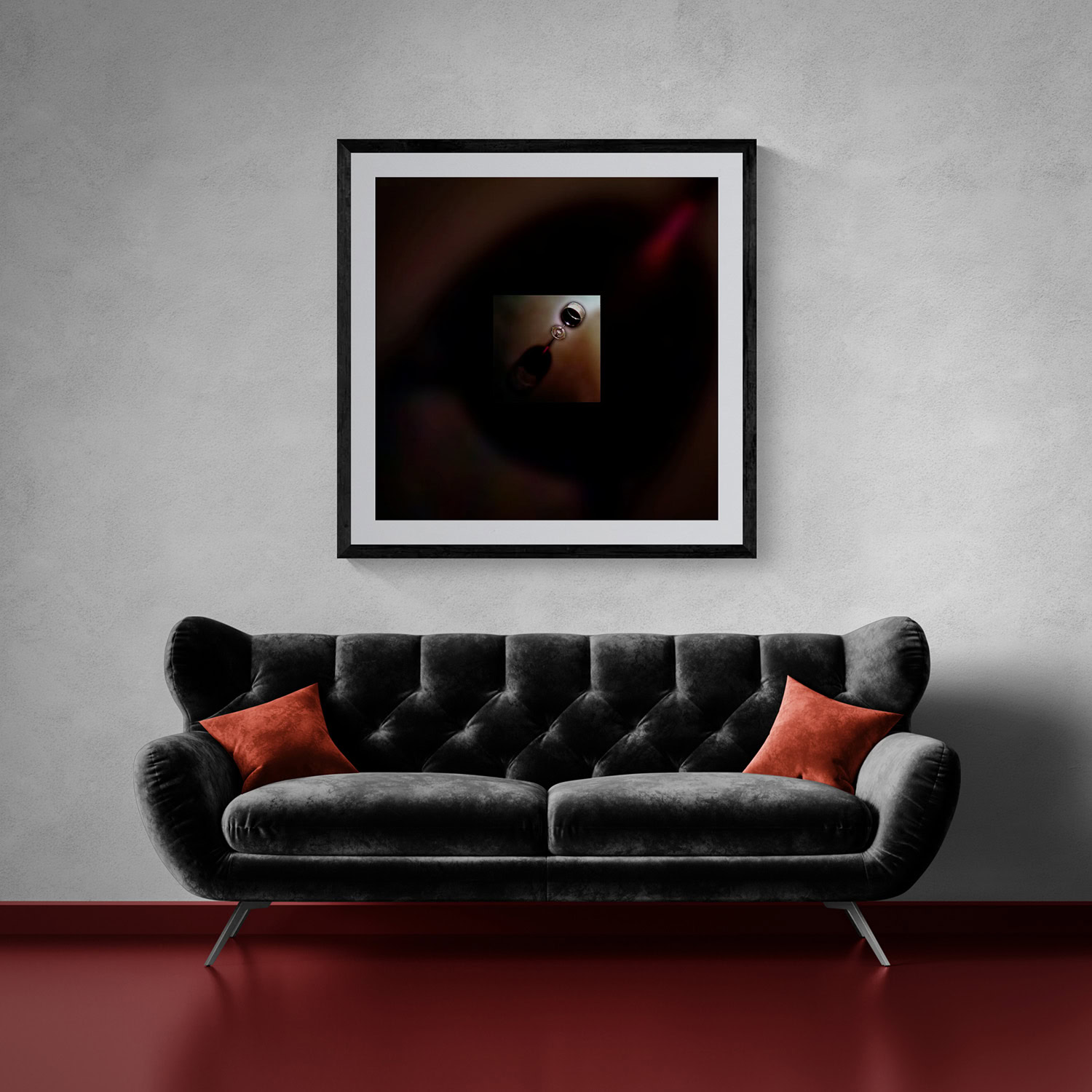 Modern art piece hanging above a black velvet sofa with orange pillows.