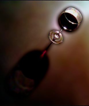 Close-up of a wine glass with red wine, artistic lighting and shadows.