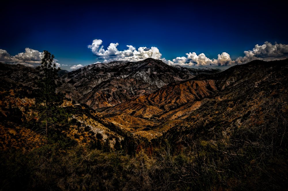 Vivid mountain landscape featuring rugged terrain and a dramatic sky in the Doug Heslep Fine Art Collection.