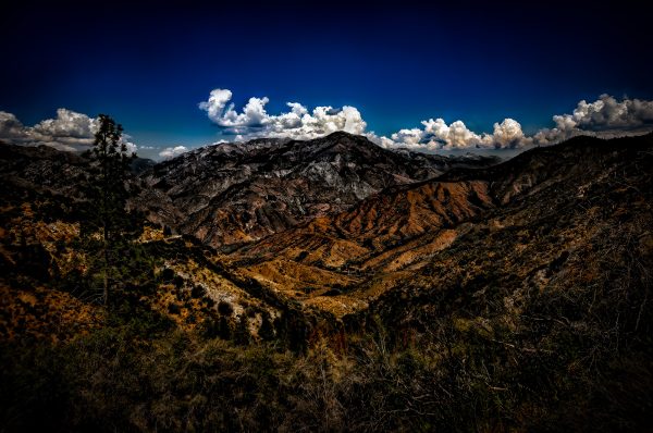 Vivid mountain landscape featuring rugged terrain and a dramatic sky in the Doug Heslep Fine Art Collection.