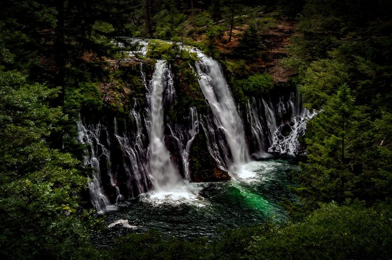 Serene waterfall in a lush green forest, capturing natural beauty and tranquility.