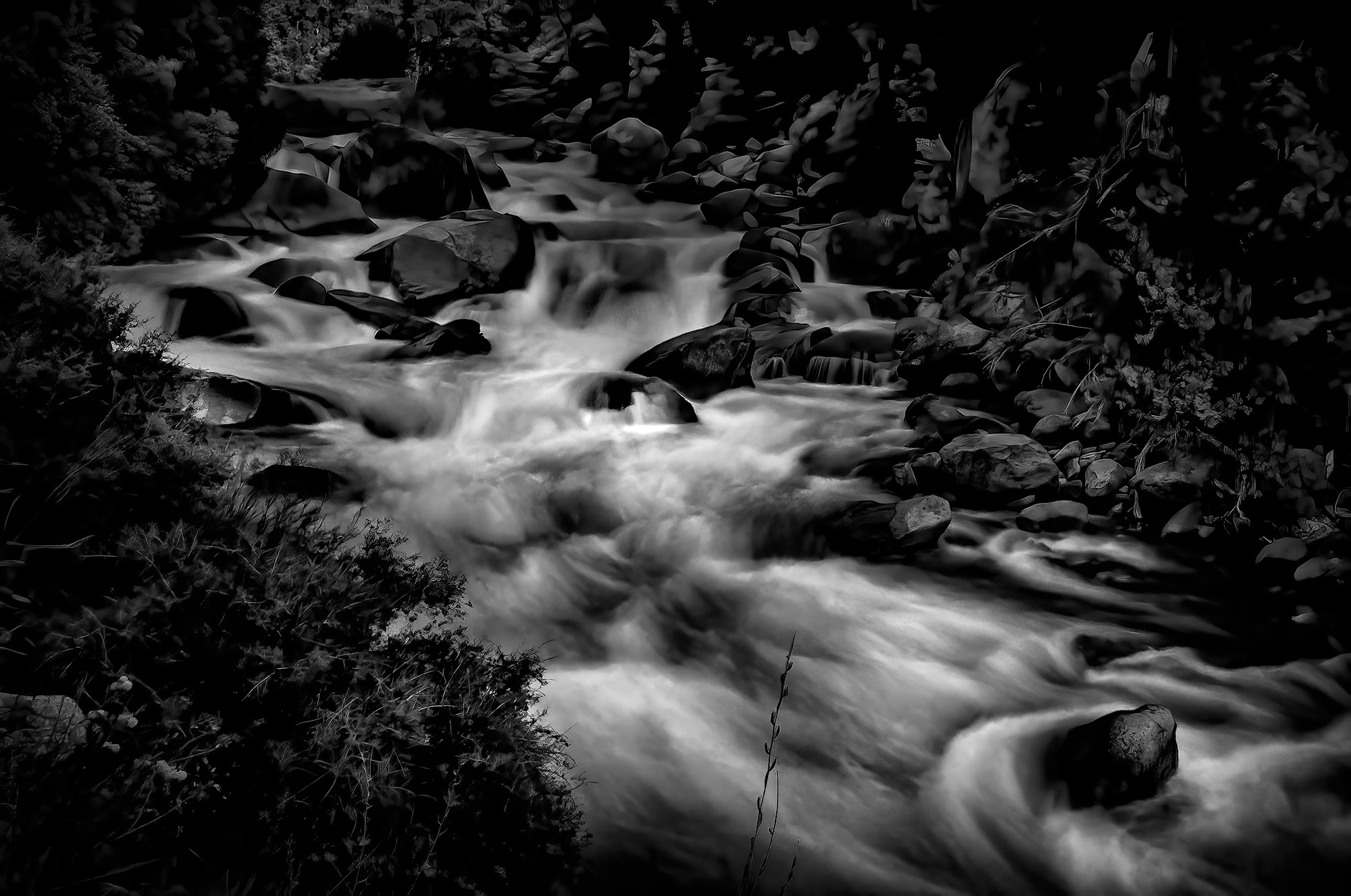A black and white mountain landscape from The Doug Heslep Fine Art Collection showcasing the Roaring King's River, rugged terrain, and dramatic skies.