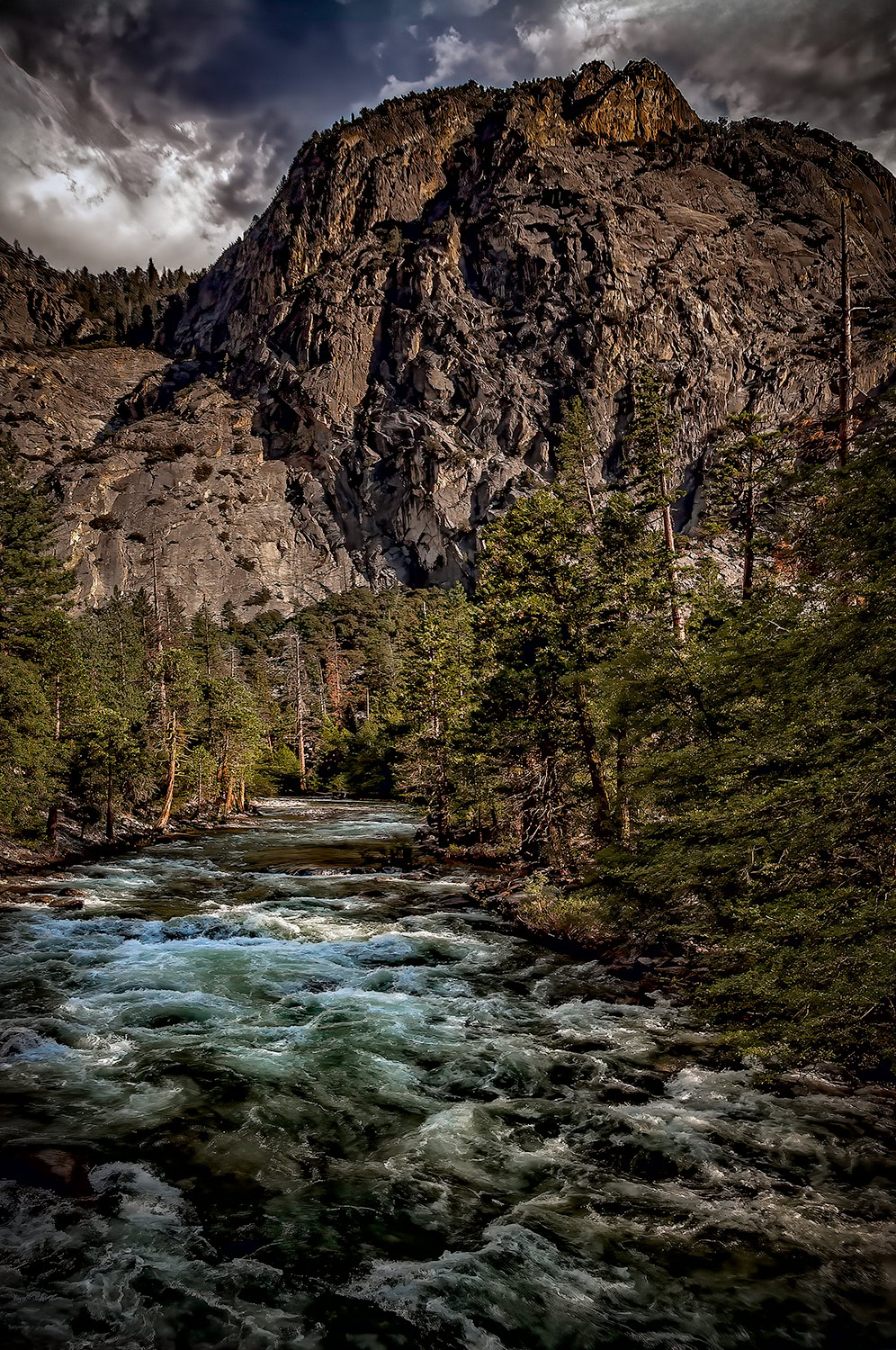 Vibrant mountain landscape featuring a rushing river and towering rocky cliffs, capturing the essence of the Doug Heslep Fine Art Collection.