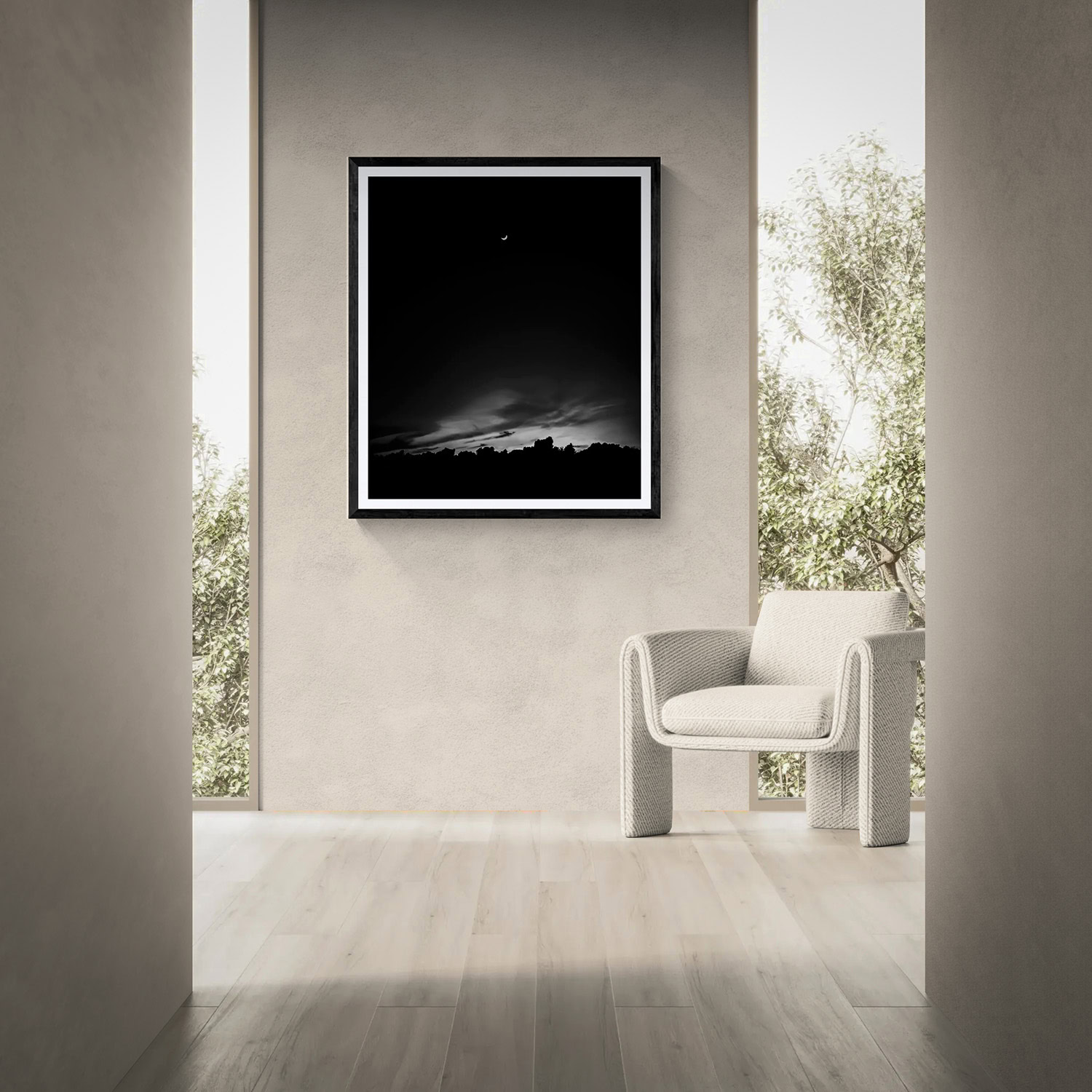 Framed night sky landscape artwork displayed on a gallery wall with a white chair nearby.