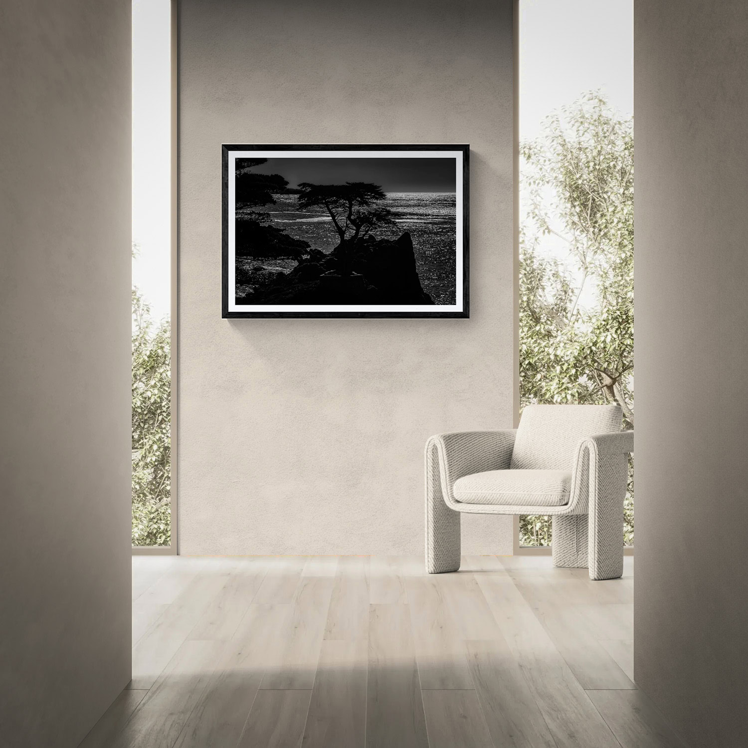 Black and white landscape photograph of a coastal scene with trees and water, displayed in a modern.