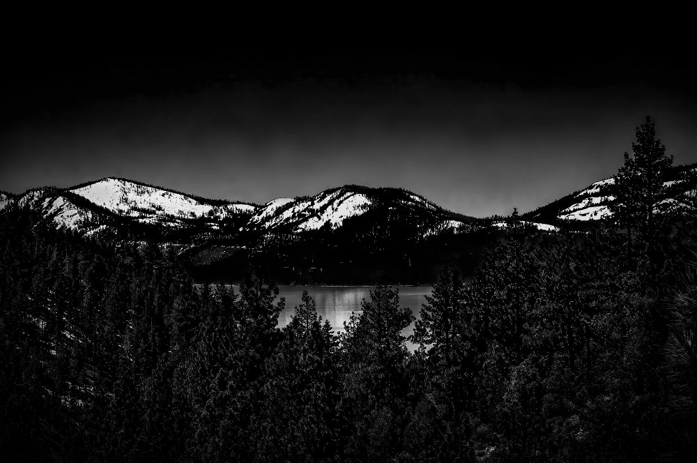 Snow-capped mountains near a lake in the Doug Heslep Fine Art Collection, showcasing stunning nature photography.