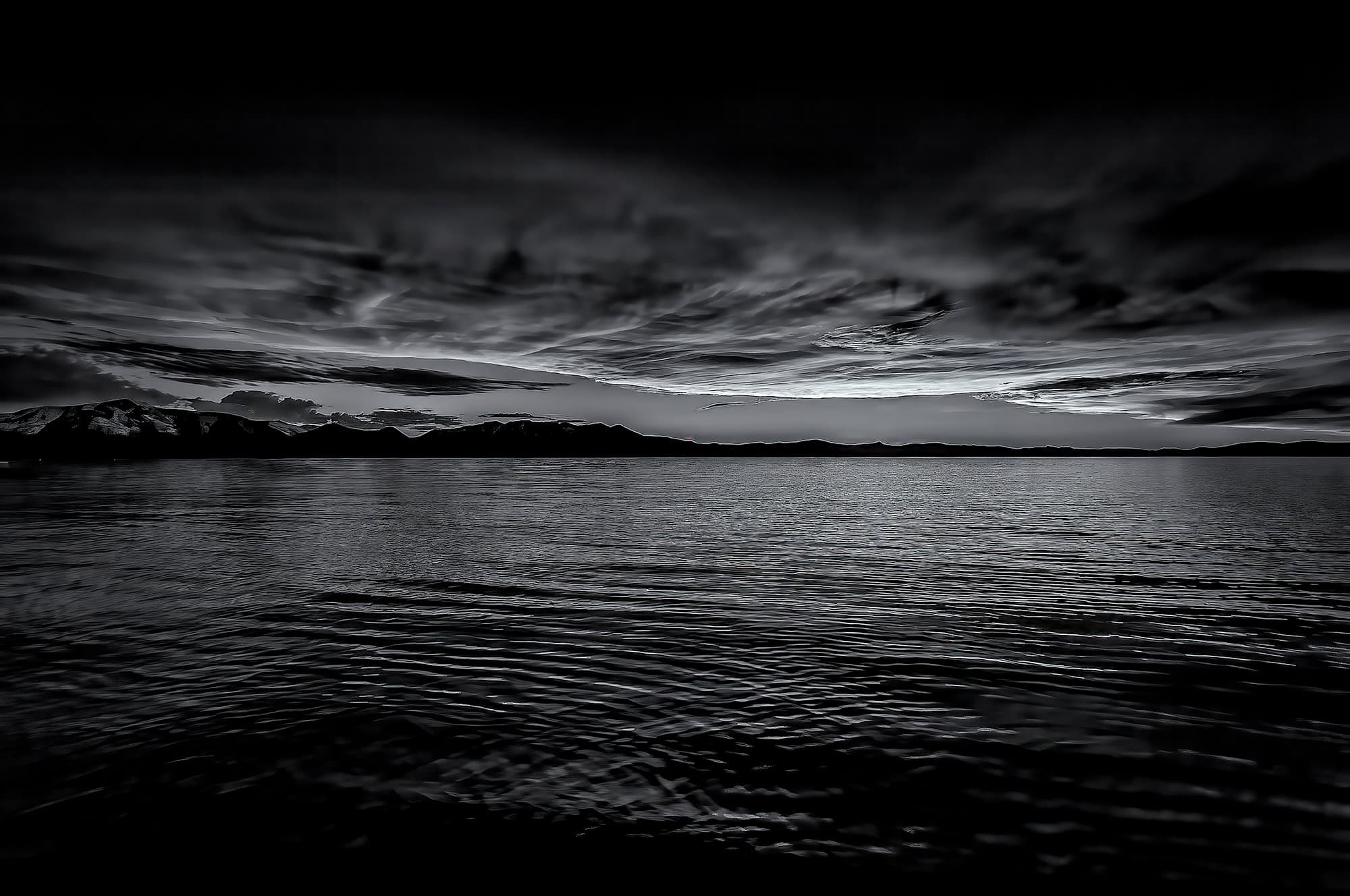 A black and white photo of a spectacular sunset looking across Lake Tahoe