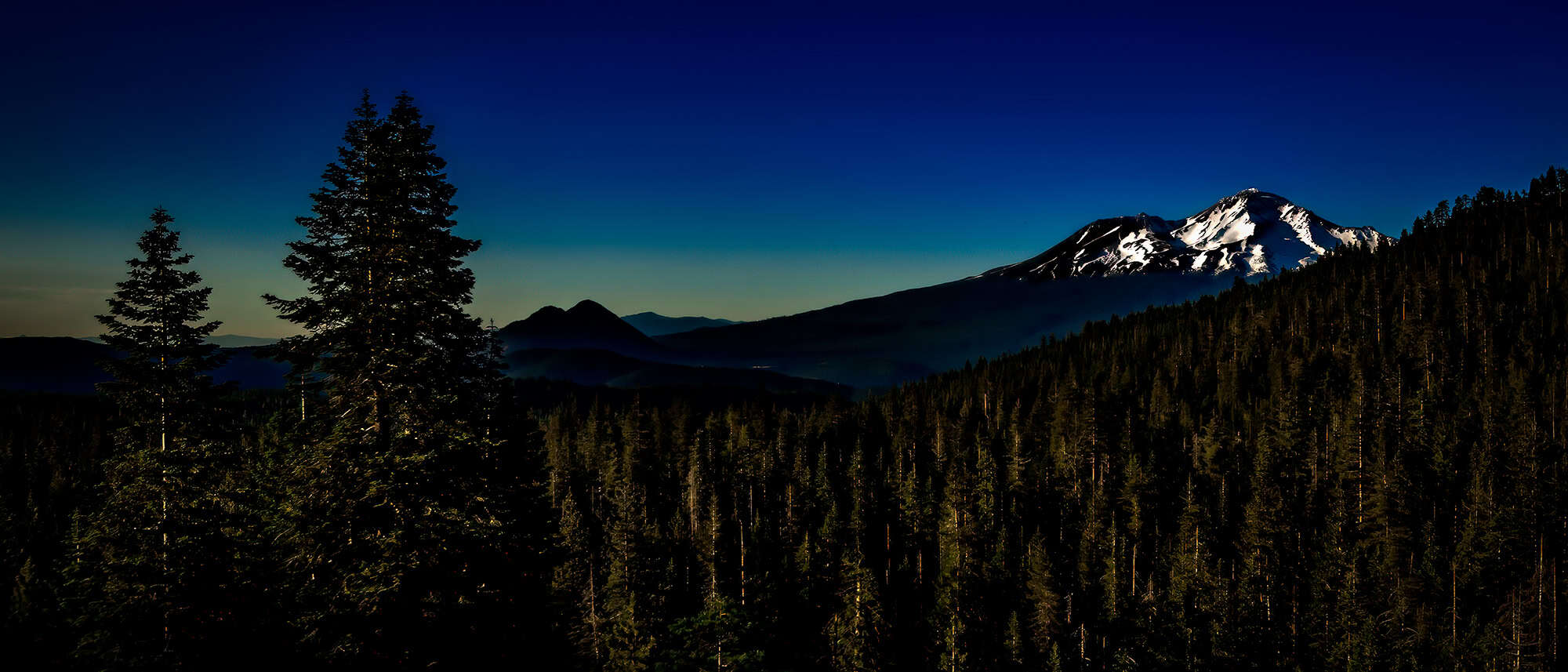 An evening view of Mount Shasta and Black Butte as seen from Castle Lake