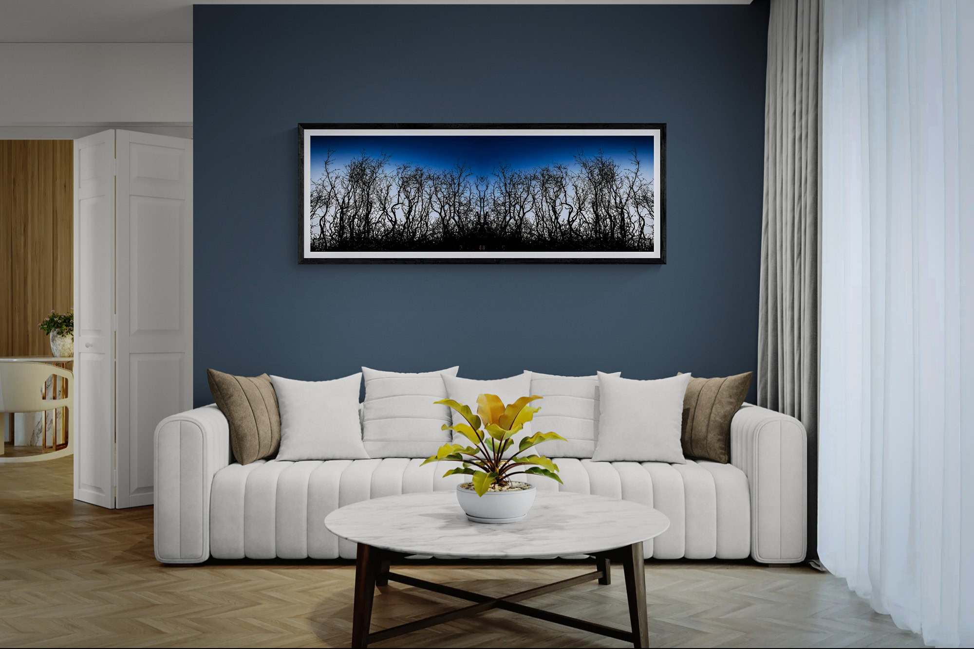 Landscape artwork featuring silhouetted trees against a blue sky, displayed in a modern living room.