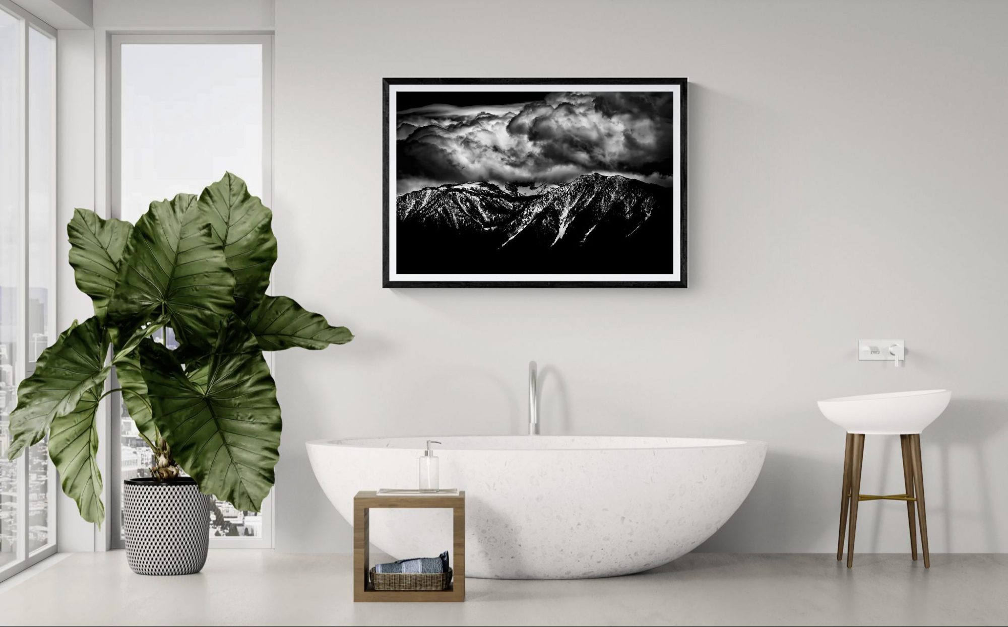 Elegant bathroom featuring a white freestanding bathtub, large green plant, and black-and-white moun.