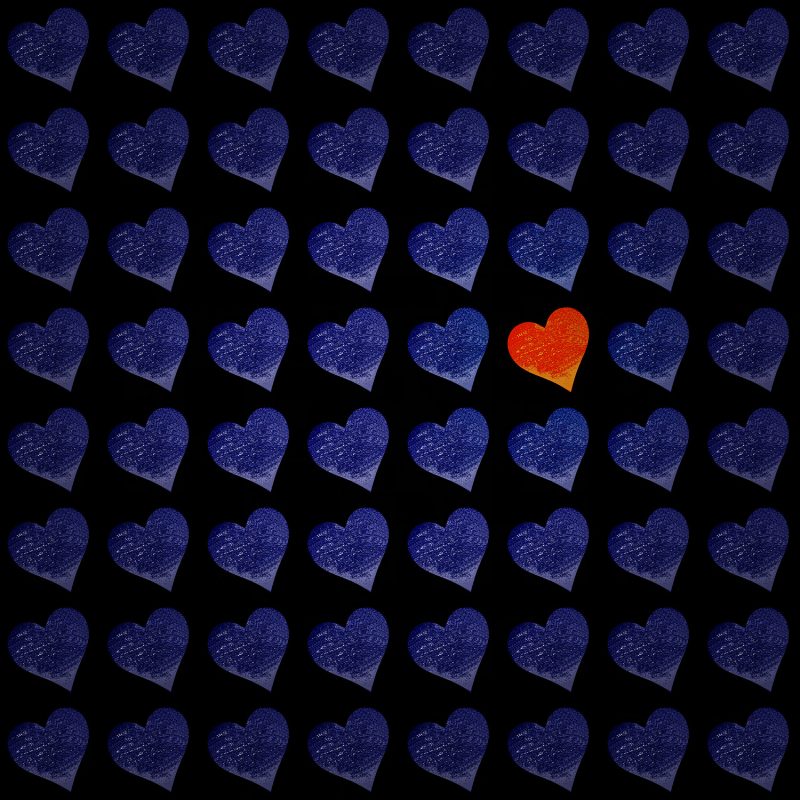 A red heart is in the middle of many blue hearts.